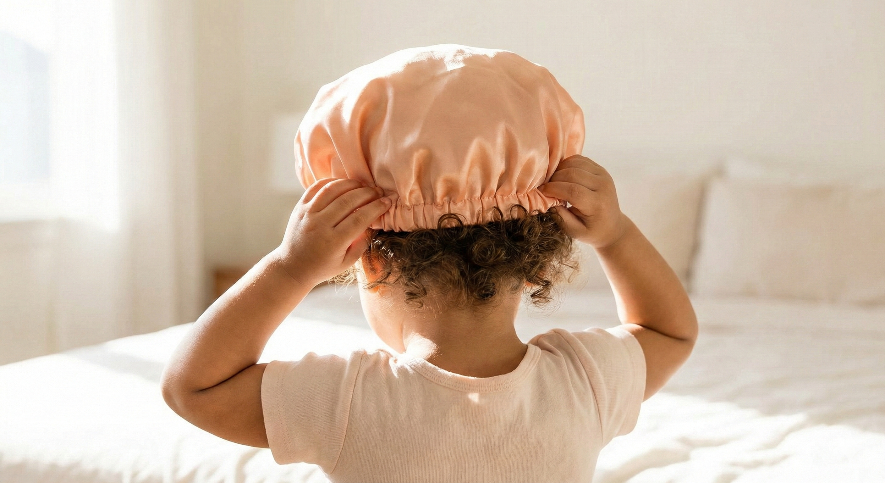 Child putting on a silk bonnet